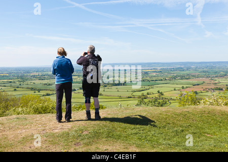 Walkers enjoying the view across the Severn Vale to the Forest of Dean from the Cotswold Way on Haresfield Hill, Gloucestershire UK Stock Photo