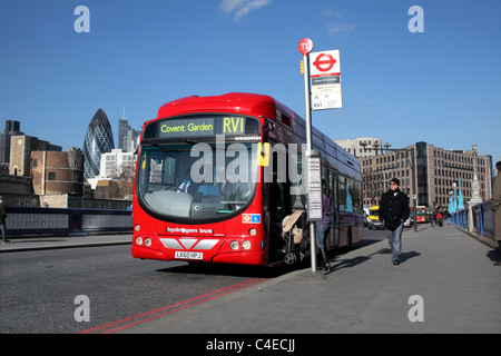Woman with a buggy getting on a hydrogen-powered fuel cell electric bus, Tower Bridge Approach, London. Stock Photo