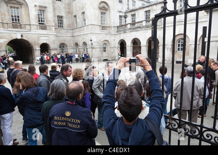 Tourists assemble to watch the changing of the guard in Horse Guard's Parade, London. Stock Photo
