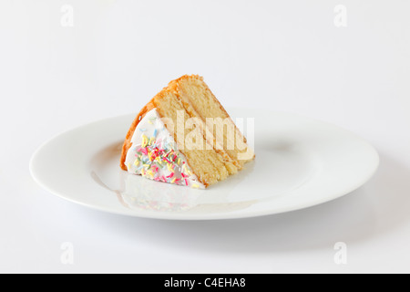 A slice of sponge cake on a white plate (for version with a fork - ref C4EH9N) Stock Photo
