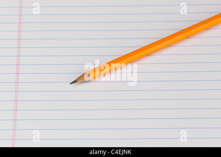 A yellow pencil on a piece of notebook paper Stock Photo