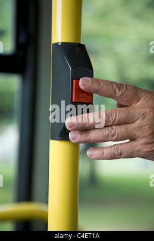 Woman pressing bell on bus Stock Photo