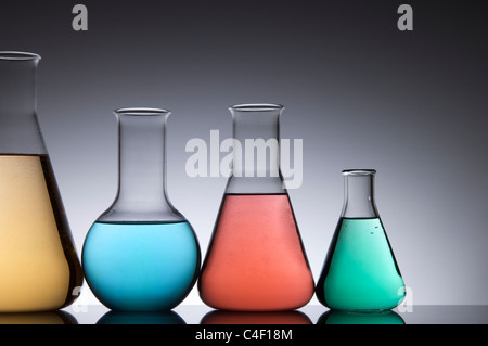 laboratory four bottles of colored liquid on a white background Stock Photo