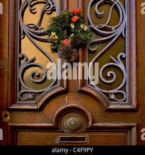 Christmas wreath on a brown front door. Stock Photo