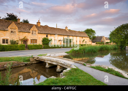 Cottages and stone footbridge in the Cotswolds village of Lower Slaughter, Gloucestershire, England. Stock Photo