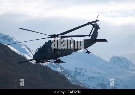 US Army UH-60 Black Hawk helicopter flying in the mountains, Alaska Stock Photo