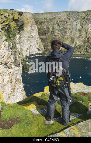 Photographer Eric Guth photographing Gannet colony, Isle of Noss, Shetland Islands, Scotland; UK Stock Photo