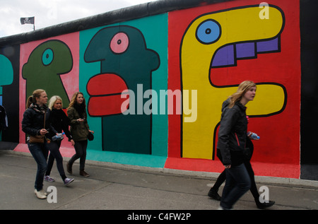 A group of people walking past the East Side Gallery in Berlin Stock Photo