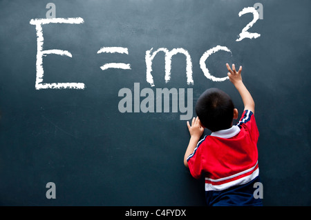boy drawing E=mc2 on the wall Stock Photo
