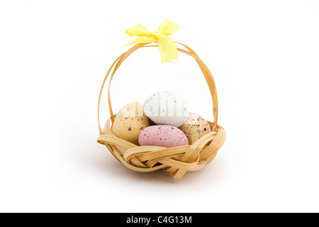 Basket of candy coated chocoalte easter eggs over white Stock Photo