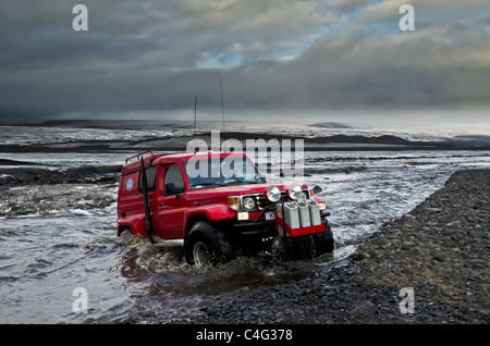 Big Red crossing the Tungnaa glacial river filled with ash from the Grimsvotn volcanic eruption, Iceland Stock Photo
