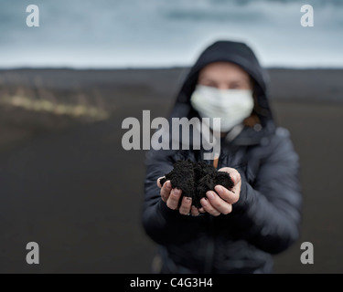 Woman holding new ash from recent Grimsvotn volcanic eruption, Iceland Stock Photo