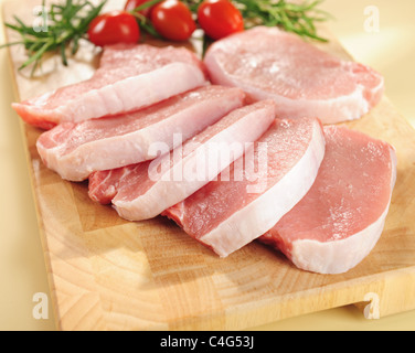 Raw pork chops. Arrangement on a cutting board. Stock Photo