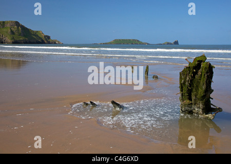 Wreck of the Helvetia on Rhossili beach in spring sunshine looking to Worm's Head Gower Peninsula Wales Cymru UK GB Stock Photo