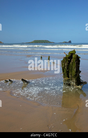 Wreck of the Helvetia on Rhossili beach in spring sunshine looking to Worm's Head Gower Peninsula Wales Cymru UK GB Stock Photo