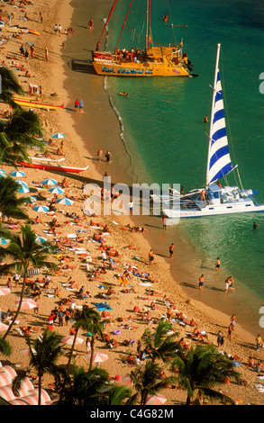 Waikiki Beach in Honolulu with catamarans and sunbathers