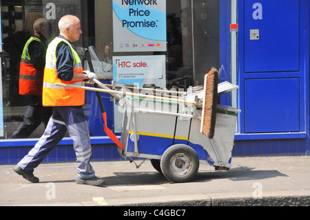 Street cleaner barrow brushes litter rubbish collection council worker Westminster Council London Stock Photo