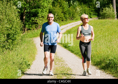 Mature or senior couple doing sport outdoors, jogging Stock Photo