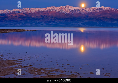 Reflections in Badwater Basin lake, Moonrise over Panamint Mountains and Badwater Basin, Death Valley National Park, California, Stock Photo