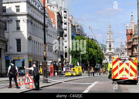 Police officers organising 'Police Tape' across 'The Strand' road during major fire incident Stock Photo