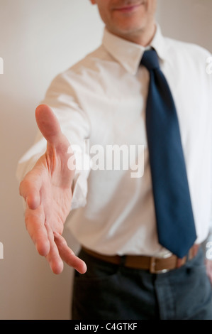Man extending his open hand, offering handshake. Stock Photo