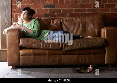 Young woman with phone on sofa