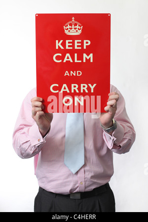 Man holding a Keep Calm And Carry On sign. Picture by James Boardman. Stock Photo