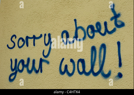 Yellowish wall having the words 'sorry about your wall!' sprayed onto it, Munich, Bavaria Stock Photo