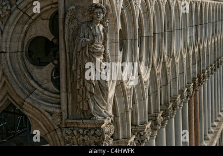 A sculptured  figure staying on a capital of the facade from the gothic Doge's Palace ( Palazzo Ducale ) in Venice, Italy Stock Photo
