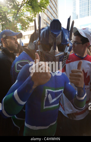 Enthusiastic Vancouver Canucks hockey fan with painted chest and mask during the outdoor crowd support game 7 of the Stanley Cup Stock Photo