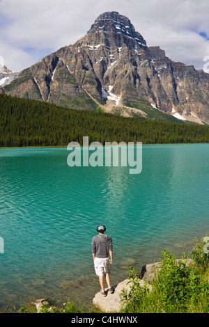 Young tourist on vacation, enjoying view of Mount Chephren and Waterfowl Lake in Canada's Banff National Park. Stock Photo