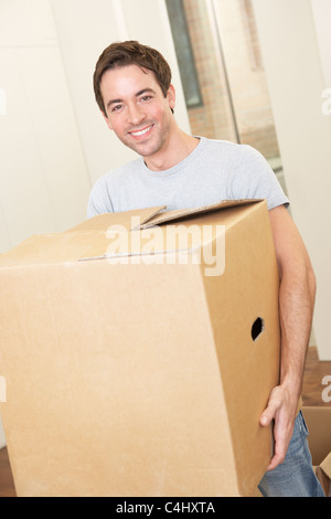Young man on moving day holding and carrying cardboard box Stock Photo