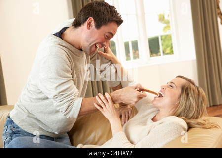 Young couple having fun laughing on sofa Stock Photo