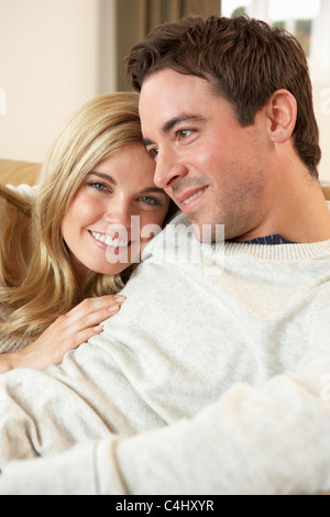 Young couple sitting and relaxing on sofa Stock Photo