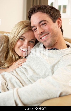 Young couple sitting and relaxing on sofa Stock Photo