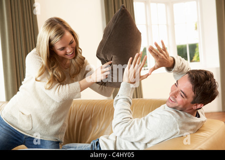 Young couple having fun laughing on sofa Stock Photo