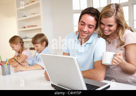 Happy young family looking and reading a laptop computer Stock Photo