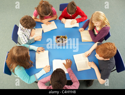 Overhead View Of Schoolchildren Working Together At Desk Stock Photo