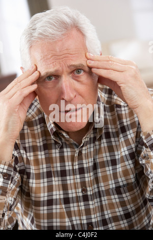 Senior Man Looking Stressed In Chair At Home Stock Photo