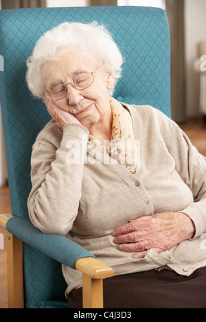 Senior Woman Resting In Chair At Home Stock Photo