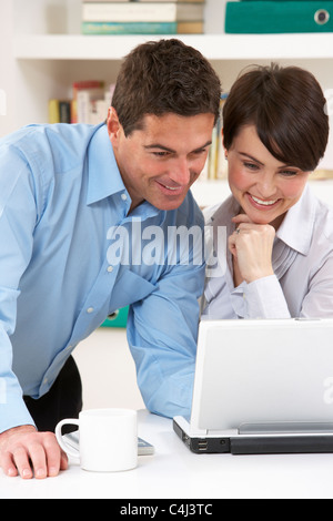Couple Working From Home Using Laptop Stock Photo