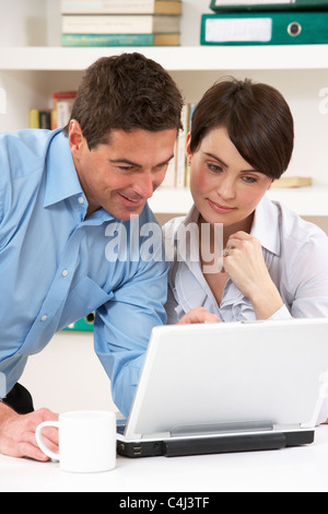 Couple Working From Home Using Laptop Stock Photo