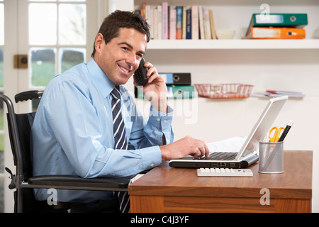 Man Working From Home Using Laptop On Phone Stock Photo