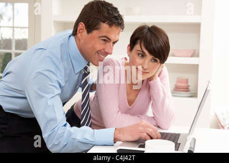 Couple Working From Home Using Laptop Stock Photo