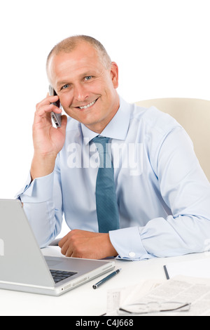 Portrait of successful smiling businessman sitting behind table Stock Photo