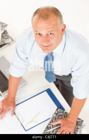 Closeup of senior man working on paperwork at his office table Stock Photo