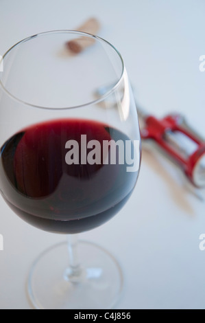Glass of red wine, cork and corkscrew. Close view. Stock Photo