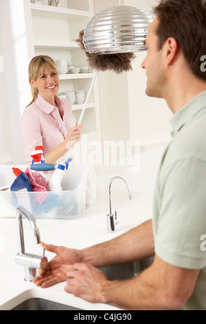 Couple Doing Housework In Kitchen Together Stock Photo