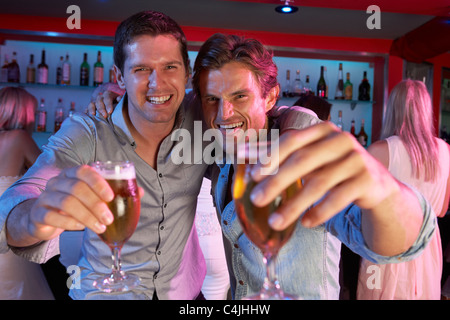 Two Young Men Having Fun In Busy Bar Stock Photo