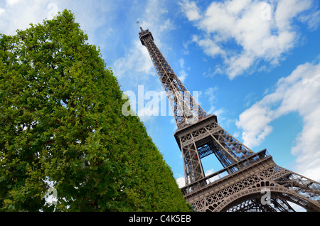An unusual view of the Eiffel Tower on a bright Summer day, framed by a hedge in the Champs des Mars, Paris. Stock Photo